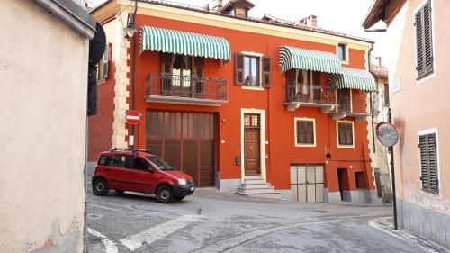 蒙多维B&B del Borgo的停在橙色建筑前面的红色汽车