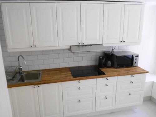 隆德隆德联排别墅公寓的厨房配有白色橱柜、水槽和微波炉