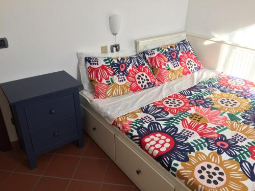 塔武利亚Villetta le Rose的床上有色彩缤纷的枕头,有床头柜