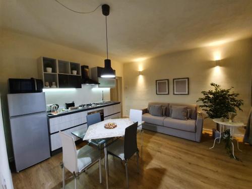 卢卡6 Via della Rosa的厨房以及带桌子和沙发的客厅。
