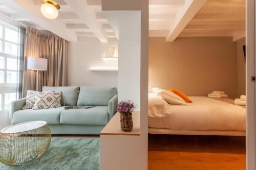 拉科鲁尼亚APARTAMENTOS FRANJA 55的客厅配有床和蓝色沙发