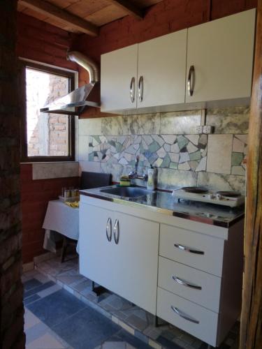 圣玛利亚Cabaña Taski Wasi的厨房配有白色橱柜和水槽