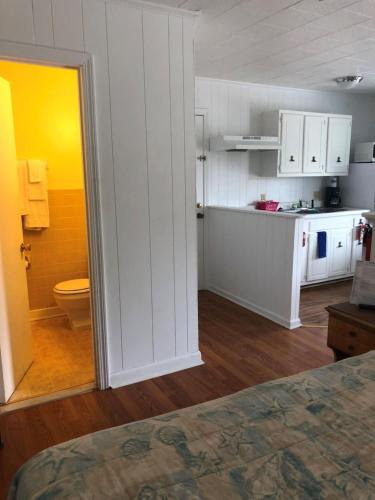 巴克斯顿Swell Motel的一间厨房,内设白色橱柜和卫生间
