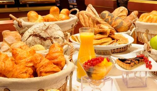 Saint-Étienne-la-Thillaye梅非庄园住宿加早餐旅馆的一张桌子,上面放着许多面包和糕点