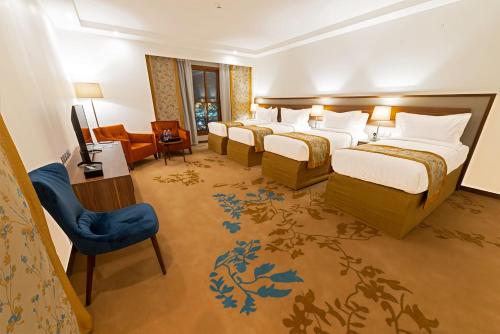 麦地那Le Bosphorus Hotel - Waqf Safi的酒店客房设有四张床和电视。