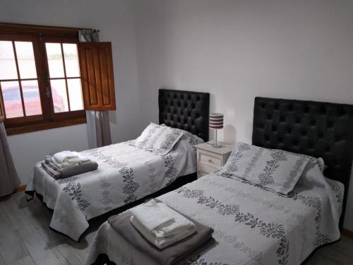科尔多瓦Casa confortable的一间卧室设有两张床和窗户。