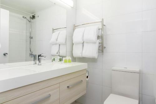 汉密尔顿Heartland Ambassador Hotel Hamilton的白色的浴室设有水槽和淋浴。