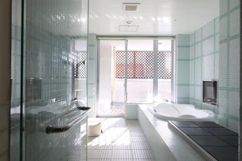 札幌C-HOTEL affetto(Adult Only)的带浴缸、水槽和窗户的浴室