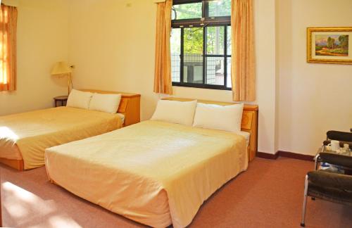 美浓高雄美浓百果园民宿的酒店客房设有两张床和窗户。