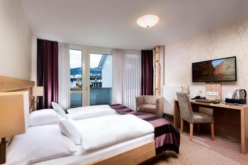 维林根维林最佳西方酒店的配有一张床和一张书桌的酒店客房