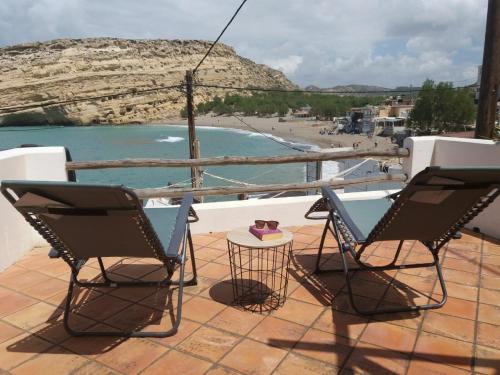 马塔拉Absolute Matala的海滩阳台配有两把椅子和一张桌子