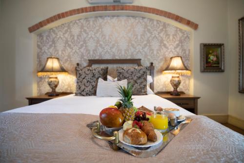 弗里尼欣Three Rivers Lodge and Villas的床上的水果和面包盘