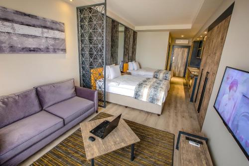 加济安泰普Shimall Hotel的客厅配有沙发和1张床