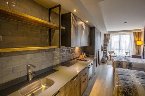 加济安泰普Shimall Hotel的一个带水槽的厨房和一张位于客房内的床