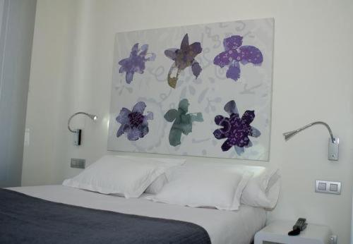 布尔戈斯艾库阿乐旅馆的卧室配有一张墙上鲜花的床