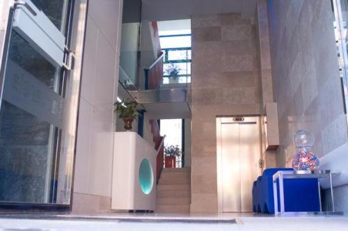 布尔戈斯艾库阿乐旅馆的走廊上设有楼梯和蓝色的手提箱