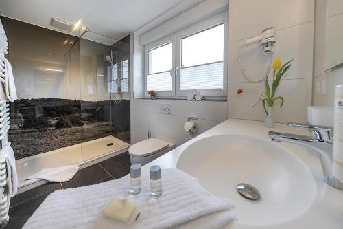 布劳博伊伦Gasthof - Hotel zum Ochsen GmbH的白色的浴室设有浴缸和水槽。