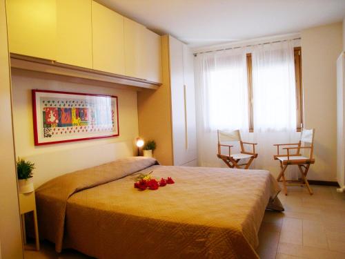 格拉多Appartamento La Croma的一间卧室,床上放着鲜花