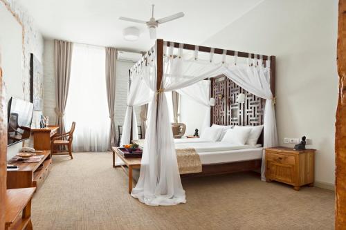 贝尔格莱德SuperB Luxury Suites的一间卧室配有一张天蓬床和一张桌子