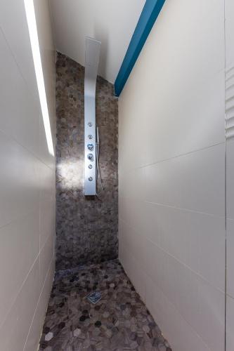 马赛Alpinias Bed and Breakfast的带淋浴的浴室(铺有石质地板)
