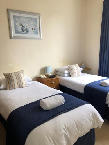 皮布尔斯Green Tree Hotel的酒店客房设有两张床,墙上挂着一张照片。