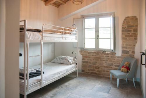 SantʼElpidio MoricoCasale Biancopecora的一间卧室配有两张双层床和椅子