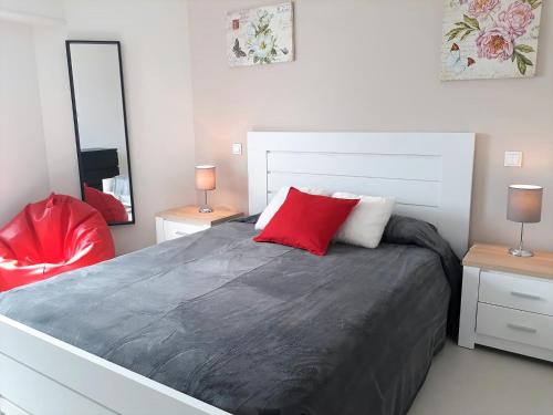奎特里拉ABMAR- Por-do-sol, Vista mar, Remodelado, Wifi, 80mt Praia的一间卧室配有一张带红色枕头的大床