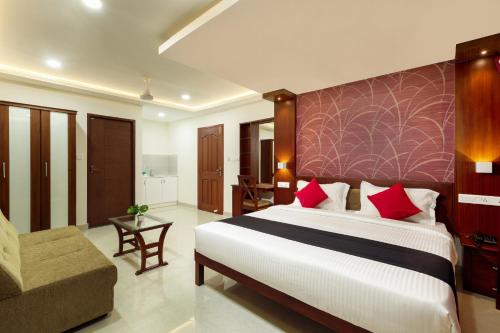 科钦Burooj Hotel的一间卧室配有一张大床和一张沙发