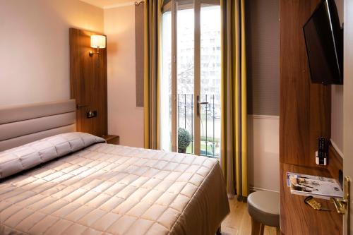 巴黎Hôtel de la Tour Eiffel的一间卧室设有一张床和一个大窗户