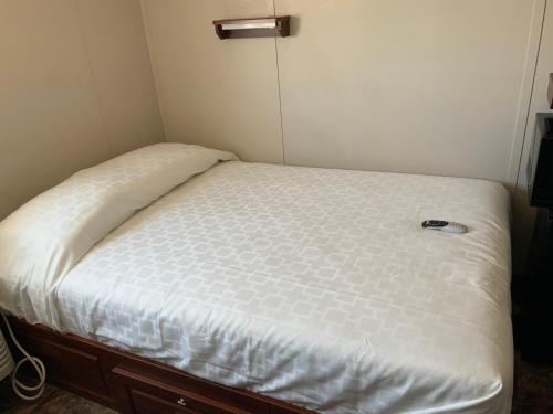 卡尔斯巴德Karbani Inn的一张位于小客房内的床铺,配有白色床垫