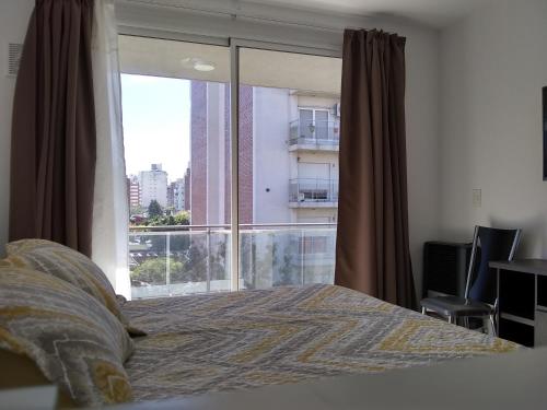 罗萨里奥Pasco 1847 Apartamento 5B的一间卧室设有一张床和一个大窗户