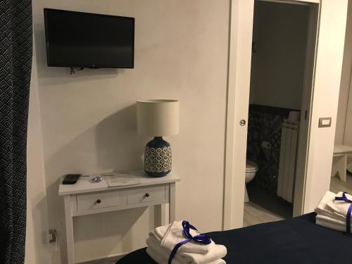 皮耶韦城B&B Casa Gaia的一间卧室配有电视和一张带台灯的桌子