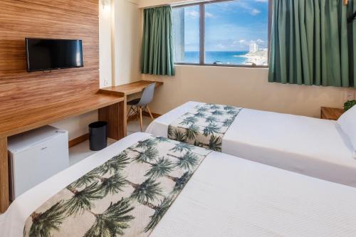 萨尔瓦多Rede Andrade Riviera Premium的酒店客房设有两张床和窗户。