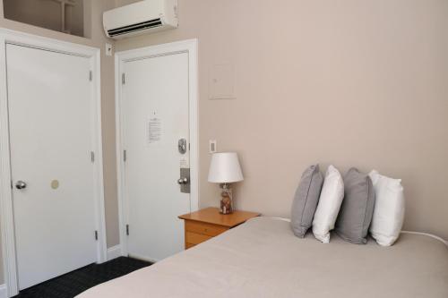 波士顿Heart of South End, Convenient, Comfy Studio #22的一间卧室配有床、灯和门