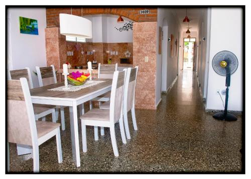 CaibariénHostal "Villa Blanca"的一间配备有白色桌椅的用餐室