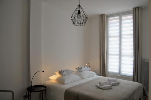 科尔马LE VOLTAIRE COLMAR CENTRE的白色卧室,配有带毛巾的床