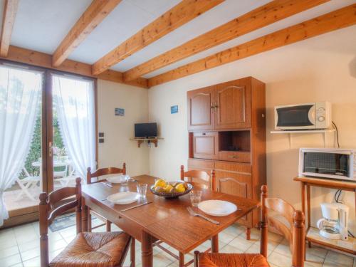 圣乔治-德迪多讷Holiday Home Jardins de l'Océan-1 by Interhome的厨房以及带木桌和椅子的用餐室。