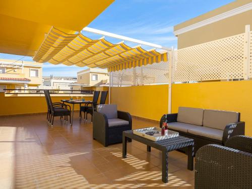 德尼亚Apartment Cascadas de la Marina-2 by Interhome的一个带桌椅的庭院和黄色的墙壁