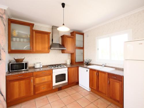 莫莱拉Holiday Home Pla del Mar by Interhome的厨房配有木制橱柜和白色冰箱。