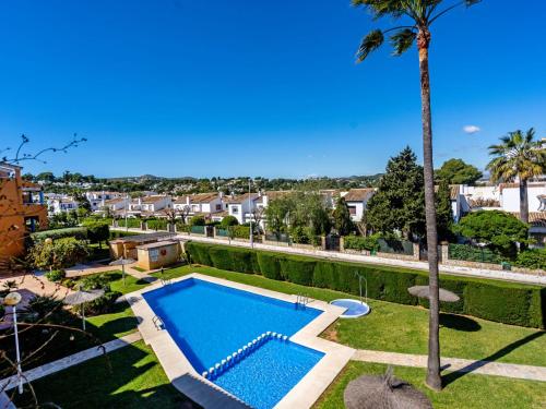 巴尔孔德马尔Apartment Menorca-3 by Interhome的棕榈树庭院中的游泳池