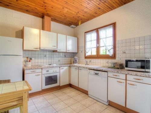 卡布勒通Holiday Home Les Vignes Océanes by Interhome的一间厨房,配有白色家电和木制天花板