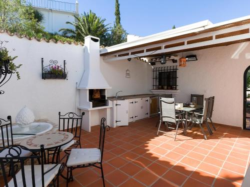 蒙特佩戈Villa Flores by Interhome的一个带桌椅的庭院和一间厨房