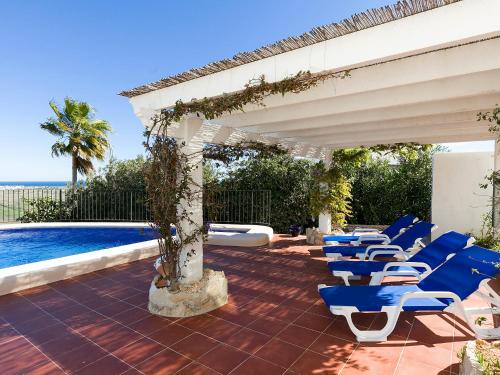 蒙特佩戈Villa Flores by Interhome的一个带蓝色椅子的庭院和一个游泳池
