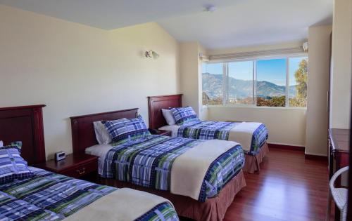 TumbacoHotel Casa Sayu的酒店客房设有两张床和窗户。