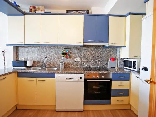 坎布里尔斯Apartment Cambrils Port by Interhome的厨房配有蓝色和黄色的橱柜和电器