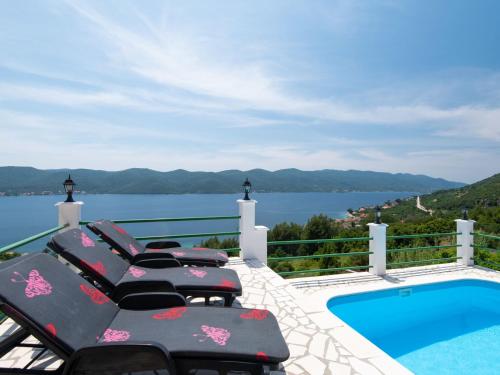 维甘Villa Anita by Interhome的阳台配有椅子,游泳池享有风景。