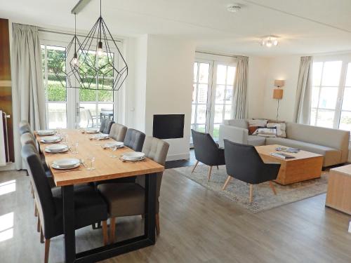 诺德克豪特Holiday Home de Witte Raaf-2 by Interhome的用餐室以及带桌椅的起居室。
