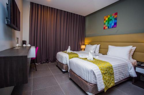 独鲁万Hotel Costa Brava的酒店客房设有两张床和电视。