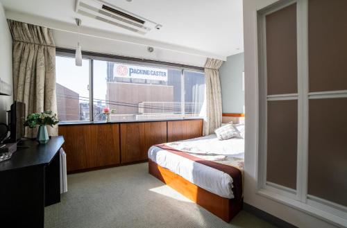 东京Tabata Oji Hotel的一间卧室设有一张床和一个大窗户