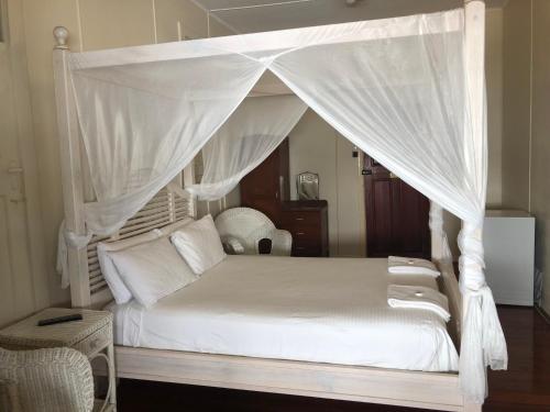 普拉瑟潘威尔斯王子酒店的一间卧室配有一张带天蓬的白色床